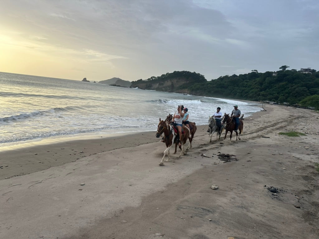 Guests riding horses along a Pacific beach in southern Nicaragua